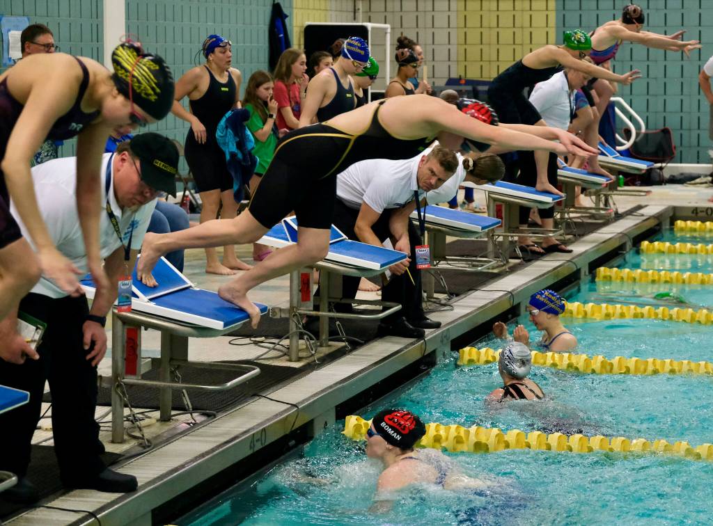 Juneau-Douglas High School: Yadaa.at Kalé senior Lucia Chapell leaves the block as classmate Parker Boman finishes her breaststroke leg in the girls 200 yard medley relay final during the ASAA Swim & Dive State Championships on Saturday at Anchorages Bartlett High School pool. (Klas Stolpe / Juneau Empire)