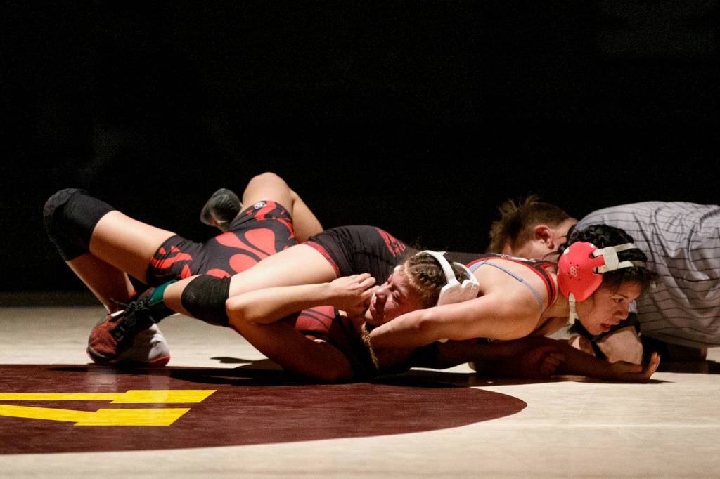 Juneau Douglass Nixie Schooler works on pinning Wrangells Hailey Cook to win the Womens 107 during the Bill Weiss Wrestling Tournament at the Clarke Cochrane Gymnasium at Ketchikan High School on Saturday. (Christopher Mullen / Ketchikan Daily News)