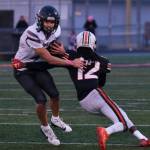Juneau senior Jayden Johnson (4) brushes off a tackle by West Anchorage junior Talon Copeland (12) during a state playoff game at West Anchorage. Johnson was selected the All-State utility player of the year and a first-team all-state receiver. (Klas Stolpe / Juneau Empire file photo)