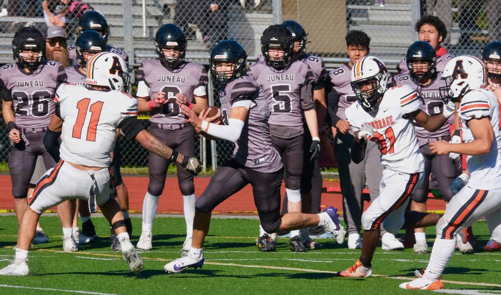 Juneau Huskies senior Jayden Johnson splits West Anchorage senior Christian Faletoi (11) and junior Christopher Casey (31) during a game against West Anchorage this season at Adair-Kennedy Memorial Park. Johnson was selected the All-State utility player of the year. (Klas Stolpe / Juneau Empir file)