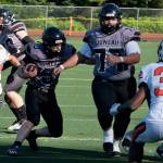 Juneau junior Ricky Tupou (77) opens a hole for sophomore Ethan Van Kirk (3) during a game against West Anchorage this season at Adair-Kennedy Memorial Park. Tupou was selected an All-State offensive lineman. (Klas Stolpe / Juneau Empire file photo)