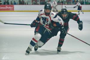 North Pole senior Kagen Kramer (9) and Juneau-Douglas High School: Yadaa.at Kalé junior Elias Schane (18) battle for puck position during the Patriots 4-2 win over the Crimson Bears on Friday at the Treadwell Ice Arena. The two teams play again Saturday at 3 p.m. (Klas Stolpe / Juneau Empire)
