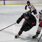 Juneau-Douglas High School: Yadaa.at Kalé junior Elliot Welch (36) moves for a puck with North Pole junior Hunter Simons (37) during the Crimson Bears 5-2 loss to the Patriots on Saturday at the Treadwell Ice Arena. (Klas Stolpe / Juneau Empire)