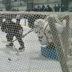 Juneau-Douglas High School: Yadaa.at Kalé sophomore Tricen Headings (34) pokes in his first career varsity goal past North Pole junior goalie Daniel Rady (74) during the Crimson Bears 5-2 loss to the Patriots on Saturday at the Treadwell Ice Arena. (Klas Stolpe / Juneau Empire)