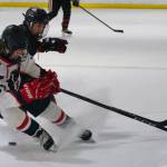 Juneau-Douglas High School: Yadaa.at Kalé senior Emilio Holbrook battles for a puck with North Pole junior Hunter Simons (37) during the Crimson Bears 5-2 loss to the Patriots on Saturday at the Treadwell Ice Arena. (Klas Stolpe / Juneau Empire)