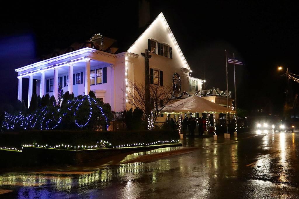 A handful of people cluster outside the Governors House during the annual Holiday Open House on Tuesday, Dec. 12, 2023. Rain and wind meant short waits for most visitors wanting to get inside. (Mark Sabbatini / Juneau Empire file photo)