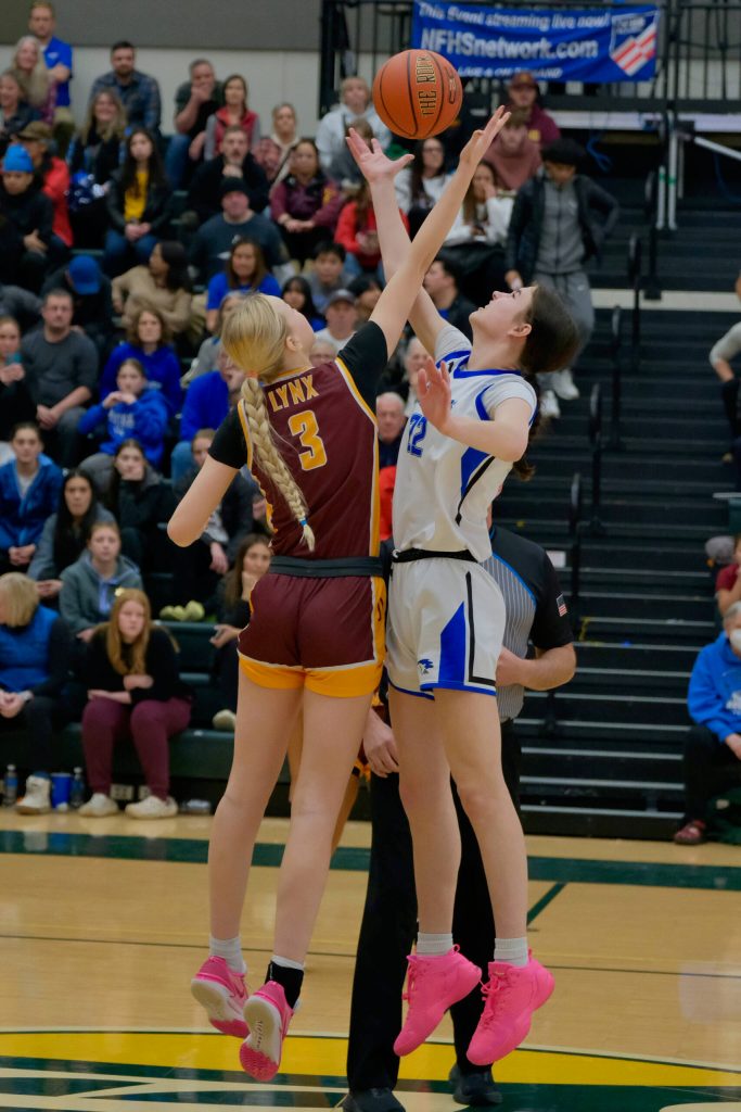 Current senior Kerra Baxter (22) jumps center for now defunct Thunder Mountain High School in last seasons ASAA state championship opening game against the Dimond Lynx current senior Evan Hamey (3). Baxter has signed to play Division II college basketball with the University of Alaska Anchorage Seawolves. She will play for Juneau-Douglas High School: Yadaa.at Kalé this year. (Klas Stolpe / Juneau Empire)