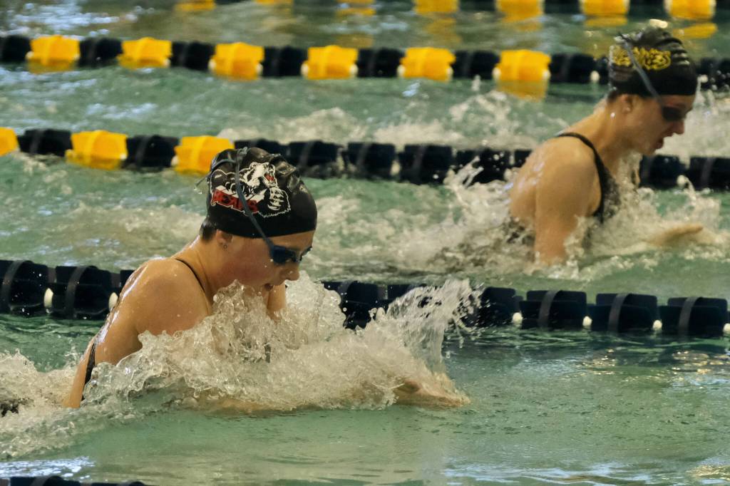 Juneau-Douglas High School: Yadaa.at Kalé junior Emma Fellman swims the breaststroke leg of the Crimson Bears winning 200-yard medley relay against Eagle River senior Maya Solomonson during the 2023 ASAA State Swim & Dive Championships at the Dimond Park Aquatic Center. (Klas Stolpe)