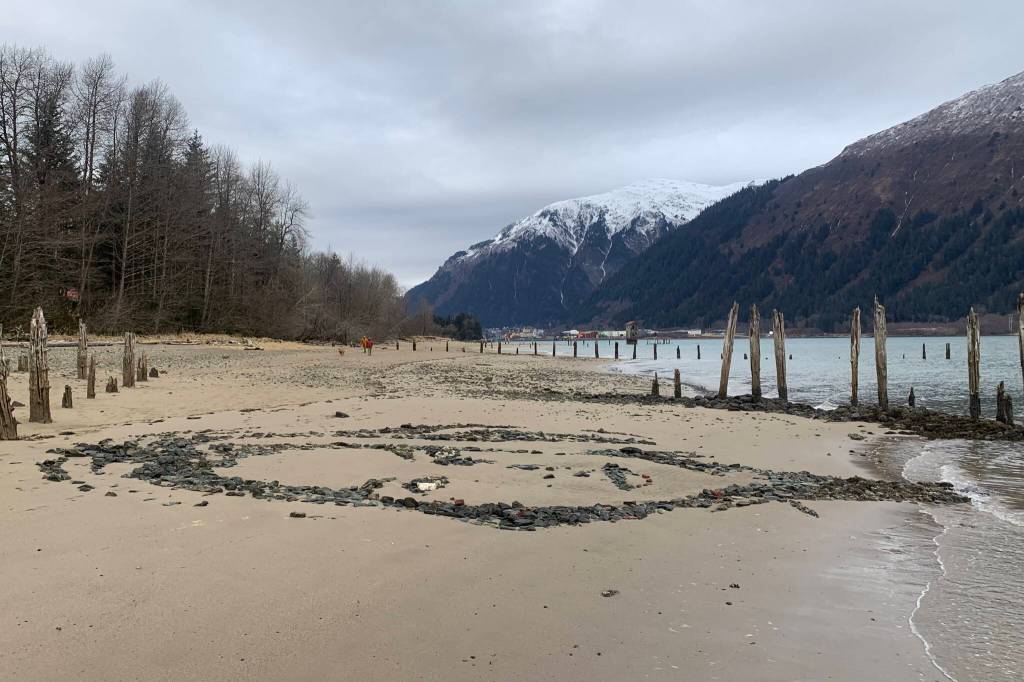 An artistic replica of a South African model is seen on the surface of Sandy Beach as the tide slowly ebbs away at its features on Monday. (Mark Sabbatini / Juneau Empire)