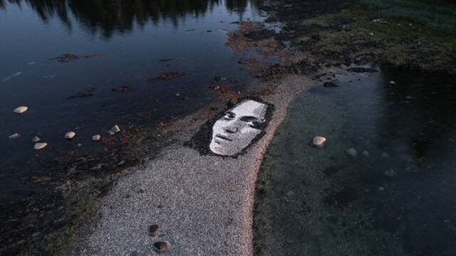 A likeness of a French model created largely with shells and black limestone rock is seen on a beach on an island near Kake. (Photo by Blake Byers)