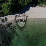 An artistic face created by artist Blake Byers is partially submerged by the tide. (Photo by Blake Byers)