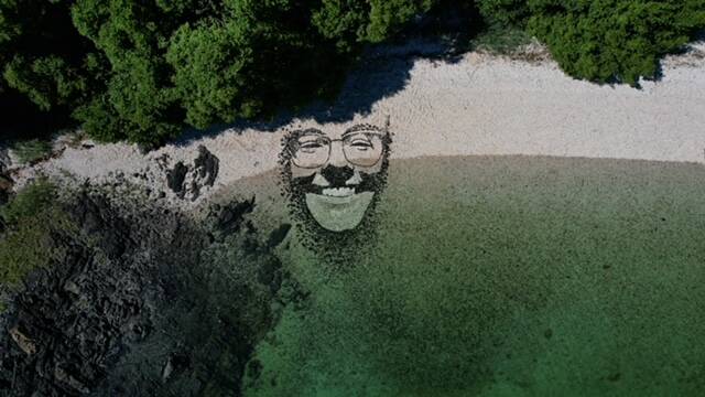 An artistic face created by artist Blake Byers is partially submerged by the tide. (Photo by Blake Byers)