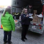 Rachel Ceja makes sure she has all of the items on her delivery list in the parking lot of St. Vincent de Paul Juneaus Teal Street complex before setting out to deliver Thanksgiving food baskets on Saturday morning. (Mark Sabbatini / Juneau Empire)