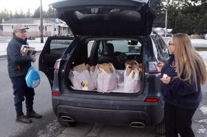 Larry Gamez and Rachel Ceja collect items for a Thanksgiving food basket to deliver to a house in the Mendenhall Valley on Saturday morning as part of St. Vincent de Pauls annual distribution program. (Mark Sabbatini / Juneau Empire)