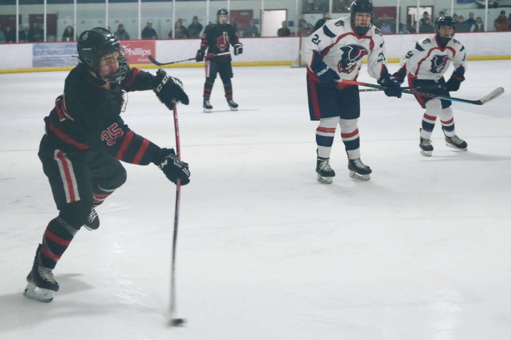 Juneau-Douglas High School: Yadaa.at Kalé senior Dylan Sowa (35) shoots a puck against North Pole in action earlier this season at Treadwell Ice Arena. Sowa had two goals against the Palmer Moose Saturday at Palmer. (Klas Stolpe / Juneau Empire file photo)