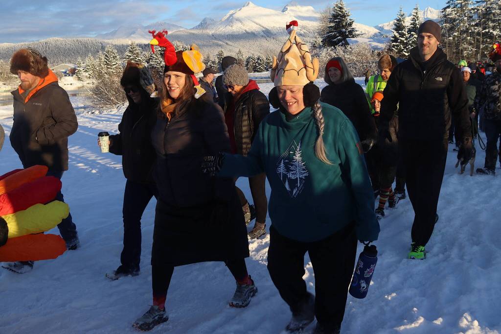 Heidi Stears (left) and JoAnn Everson wear live- and cooked-turkey hats, respectively, while participating in the annual Turkey Trot 5K and 1 Mile Fun Run on Thursday along the Airport Dike Trail. (Mark Sabbatini / Juneau Empire)