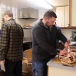 Ryan Friend (right) carves a turkey while other members of his extended family help prepare an annual community Thanksgiving Day feast hosted by The Salvation Army Juneau Corps at the Juneau Yacht Club. (Mark Sabbatini / Juneau Empire)