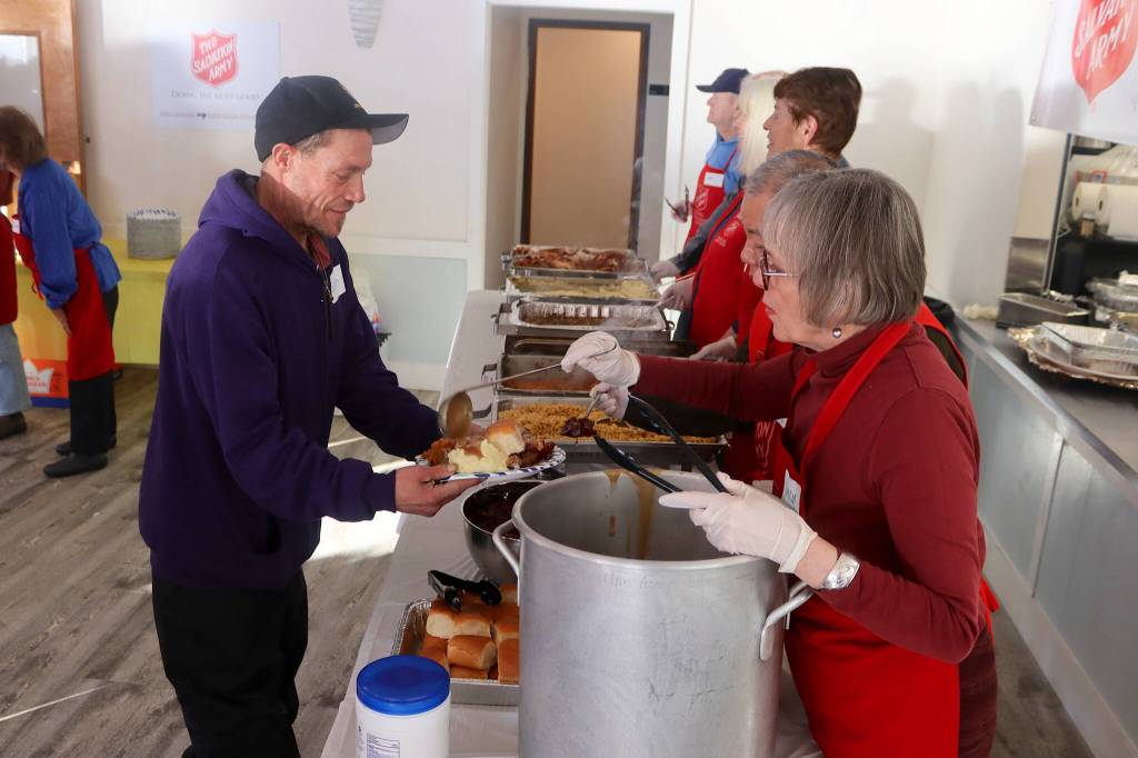 Volunteers prepare traditional Thanksgiving Day meal plates during a communal meal Thursday at the Juneau Yacht Club. (Mark Sabbatini / Juneau Empire)