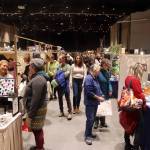 Shoppers and vendors mingle along rows of booths in the main ballroom at Centennial Hall during the Juneau Public Market on Friday. (Mark Sabbatini / Juneau Empire)