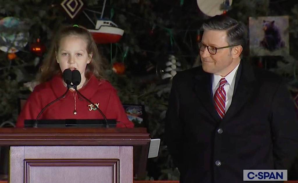 Rose Burke, 9, a fourth-grade student from Kenai, reads her winning essay for the U.S. Capitol Christmas Tree during a lighting ceremony Tuesday night in Washington, D.C., as U.S. House Speaker Mike Johnson watches. (Screenshot from C-SPAN broadcast)