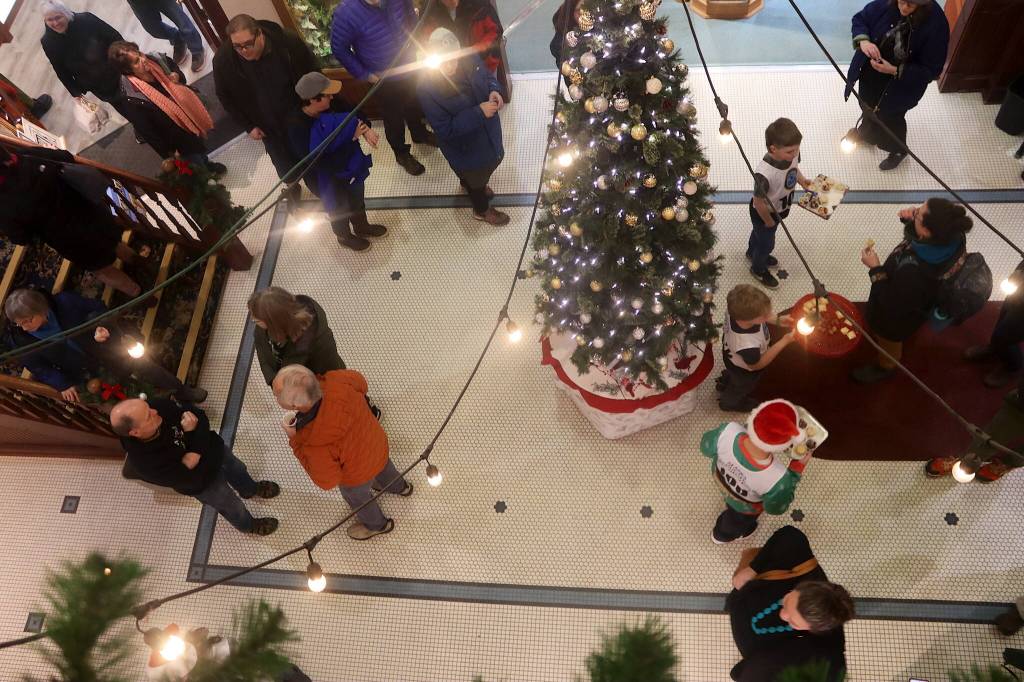 Members of the Juneau Ski Team offer cookies and other treats to people in the Senate Mall during Gallery Walk on Friday. (Mark Sabbatini / Juneau Empire)