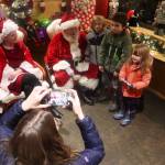 Ms. and Mr. Claus (Carolyn Bouvier and Dale Hudson ) pose with Gavin Robertson, 7, Emmett Heimbigner, 7, and Adren Heimbigner, 3, as Ashley Heimbigner takes their photo at the Heritage Coffee cafe in the center of downtown Juneau during Gallery Walk on Friday. (Mark Sabbatini / Juneau Empire)