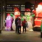 A trio of humans is dwarfed by a quartet of Christmas characters in a storefront on South Franklin Street during Gallery Walk on Friday. (Mark Sabbatini)