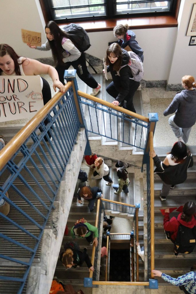 Students climb the stairs at the Alaska State Capital on Thursday morning after marching from Juneau-Douglas High School: Yadaa.at Kalé as part of a statewide protest on April 4, 2024, calling for more public school funding. (Mark Sabbatini / Juneau Empire)