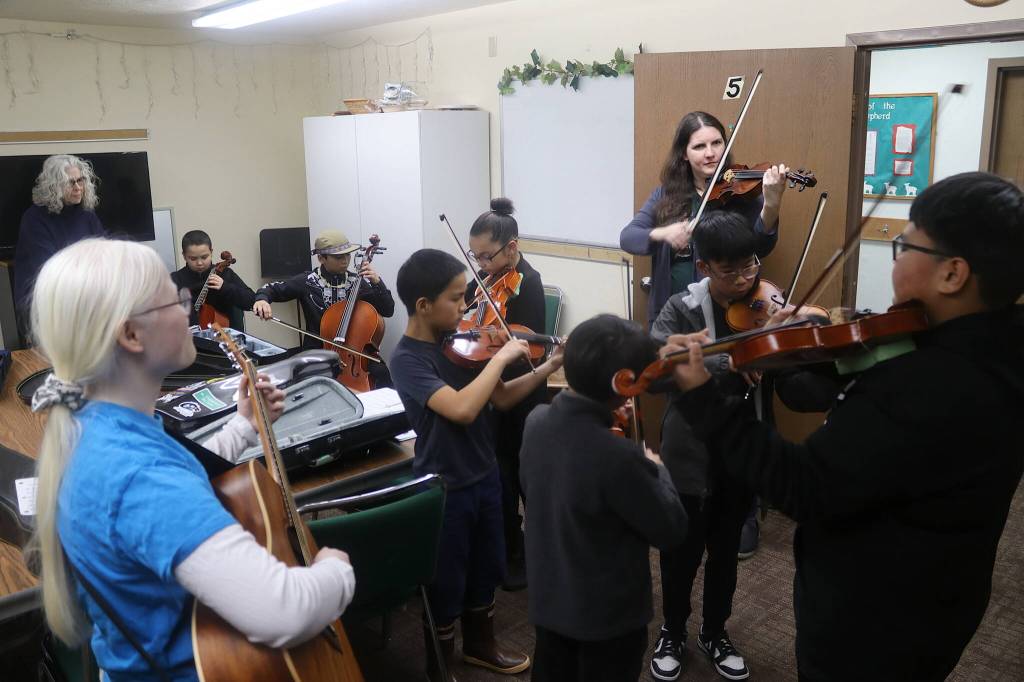 Students and instructors with the Juneau Alaska Music Matters program warm up in the basement of the parish hall at St. Pauls Catholic Church before performing with a mariachi band from Anchorage as part of a Feast Day of Our Lady of Guadalupe celebration Sunday. (Mark Sabbatini / Juneau Empire)
