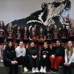 The 2024-25 Juneau-Douglas High School: Yadaa.at Kalé Crimson Bears Girls Basketball team. Standing, from left-to-right, senior Kerra Baxter (22), junior Gwen Nizich (11), freshman Lydia Goins (15), senior Addison Wilson (10), sophomore Layla Tokuoka (14), junior Cambry Lockhart (3), sophomore June Troxel (5), senior Mary Johnson (4), freshman Sadie Lockhart (13), sophomore Bergen Erickson (12), freshman Athena Warr (21) and senior Cailynn Baxter (23). Seated l-r: Senior manager Nadia Wilson, head coach Tanya Nizich, assistant coaches Jasmine James, Angie Kemp, Nicole Fenumiai, and junior manager Jadyn Cook. (Klas Stolpe / Juneau Empire)
