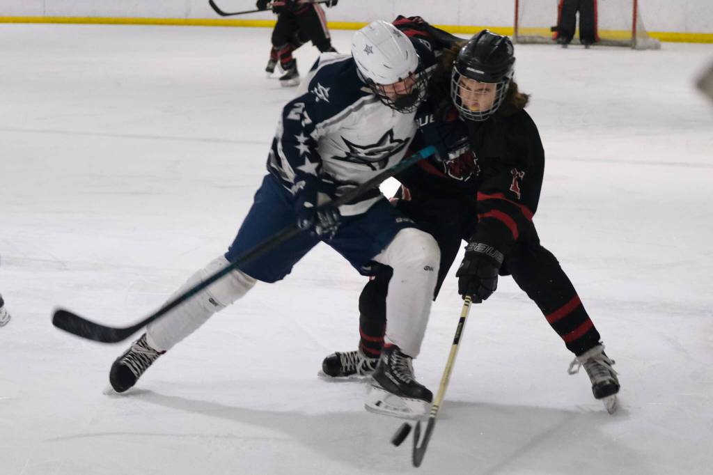 Soldotnas Keegan Myrick and Juneau-Douglas High School: Yadaa.at Kalé sophomore Caden Morris battle for a puck during Fridays 4-3 Crimson Bears loss to the visiting Stars at Treadwell Ice Arena. (Klas Stolpe / Juneau Empire)