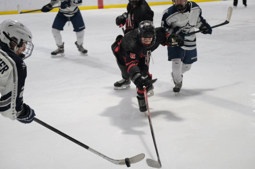 Juneau-Douglas High School: Yadaa.at Kalé senior Zander Smith (8) battles for a puck with Soldotnas Eli Settlemyer (left) during Fridays the Crimson Bears 4-3 loss to the visiting Stars at Treadwell Ice Arena. (Klas Stolpe / Juneau Empire)