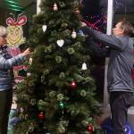 Pat McLear (left) and Taylor Dunn hang hand-decorated memorial ornaments on a Christmas tree during a Light Up a Life community celebration hosted by the hospitals Home Health and Hospice program Friday evening. (Mark Sabbatini / Juneau Empire)