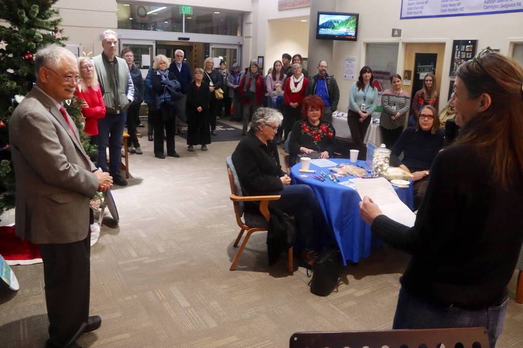 Bob Urata (left), a doctor credited with helping establish and grow hospice care in Juneau, and Mandy Mallott, daughter of the one of the first patients in Bartlett Regional Hospitals Home Health and Hospice program, address attendees at a Light Up a Life community celebration Friday evening at the hospital. (Mark Sabbatini / Juneau Empire)