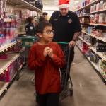 Charles John, 10, browses the aisles of Fred Meyer with Mitch Cook, a training sergeant at Lemon Creek Correctional Center, during the annual Shop With A Cop event Saturday. (Mark Sabbatini / Juneau Empire)