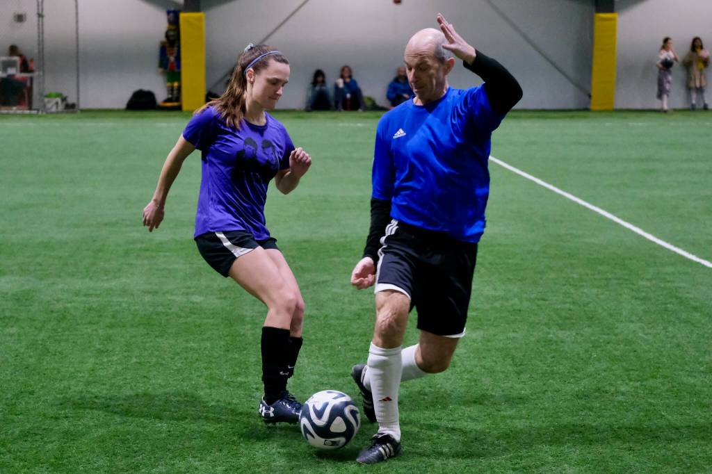 The Wet Bandits Shannon Hendricks and the Nutcrackers Kyle Hebert play a ball during the opening night of the Holiday Cup soccer tournament at the Dimond Park Field House on Wednesday. The 32nd annual holiday tournament runs through Dec. 31. (Klas Stolpe / Juneau Empire)