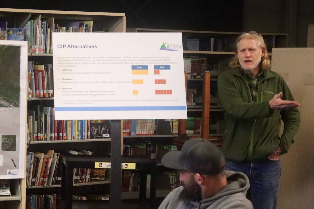 Alan Steffert, a project engineer for the City and Borough of Juneau, explains alternatives considered when assessing infrastructure improvements including utilities upgrades during a meeting to discuss a proposed fee increase Thursday night at Thunder Mountain Middle School. (Mark Sabbatini / Juneau Empire)