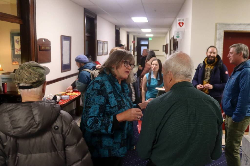 State Rep. Sara Hannan talks with visitors outside her office at the Alaska State Capitol during the annual holiday open house hosted by Juneaus legislative delegation on Friday. (Mark Sabbatini / Juneau Empire)