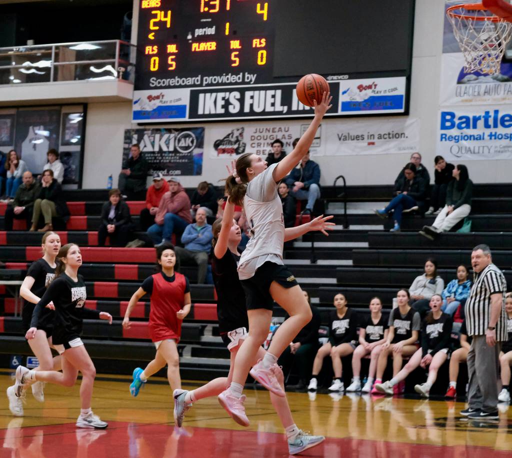 2019 Juneau-Douglas High School: Yadaa.at Kalé graduate Caitlin Pusich scores as Crimson Bears Lydia Goins and June Troxel, 2022 grad Johanna Pasion and the Crimson Bears Athena Warr give chase during alumni games Monday at the George Houston Gymnasium. (Klas Stolpe / Juneau Empire)