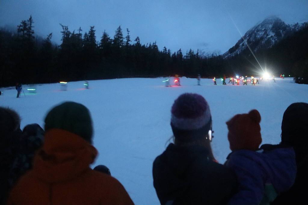 Skiers carrying neon lights descend Muskeg Run at Eaglecrest Ski Area during the resorts annual Christmas Eve Torchlight Parade on Tuesday. (Mark Sabbatini / Juneau Empire)