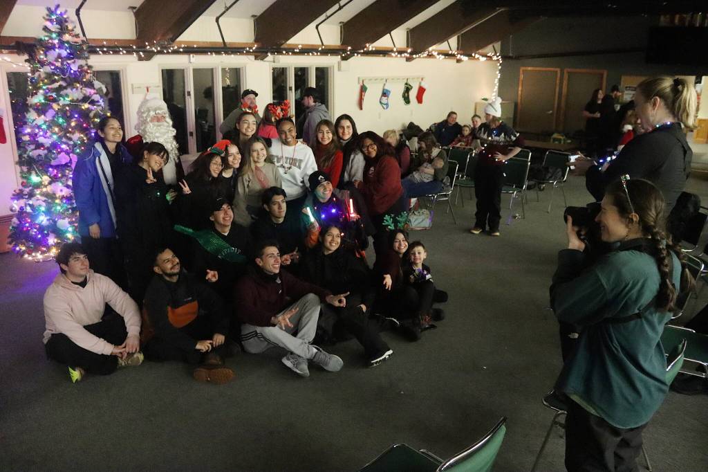Eaglecrest Ski Area employees from Central and South America who participating in the J-1 student visa program pose for a picture with Santa during the resorts annual Christmas Eve Torchlight Parade gathering on Tuesday. (Mark Sabbatini / Juneau Empire)