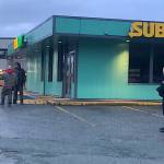 Berton Tullis (wearing a black jacket at left) greets a man who got into an angry discussion with Juneau Police Department officers following the fatal shooting of a woman by an officer near the Nugget Mall on Wednesday morning. Both men left the scene peacefully. (Mark Sabbatini / Juneau Empire)