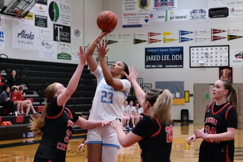 Chugiak sophomore Natalie Farr (23) floats a shot over Kenai junior Ellsi Miller (33), junior Mckenzie Spence (23) and freshman Hallie Songer (34) during the Mustangs 43-34 win over the Cardinals in the opening game of the George Houston Capital City Classic Friday in Juneau. (Klas Stolpe / Juneau Empire)