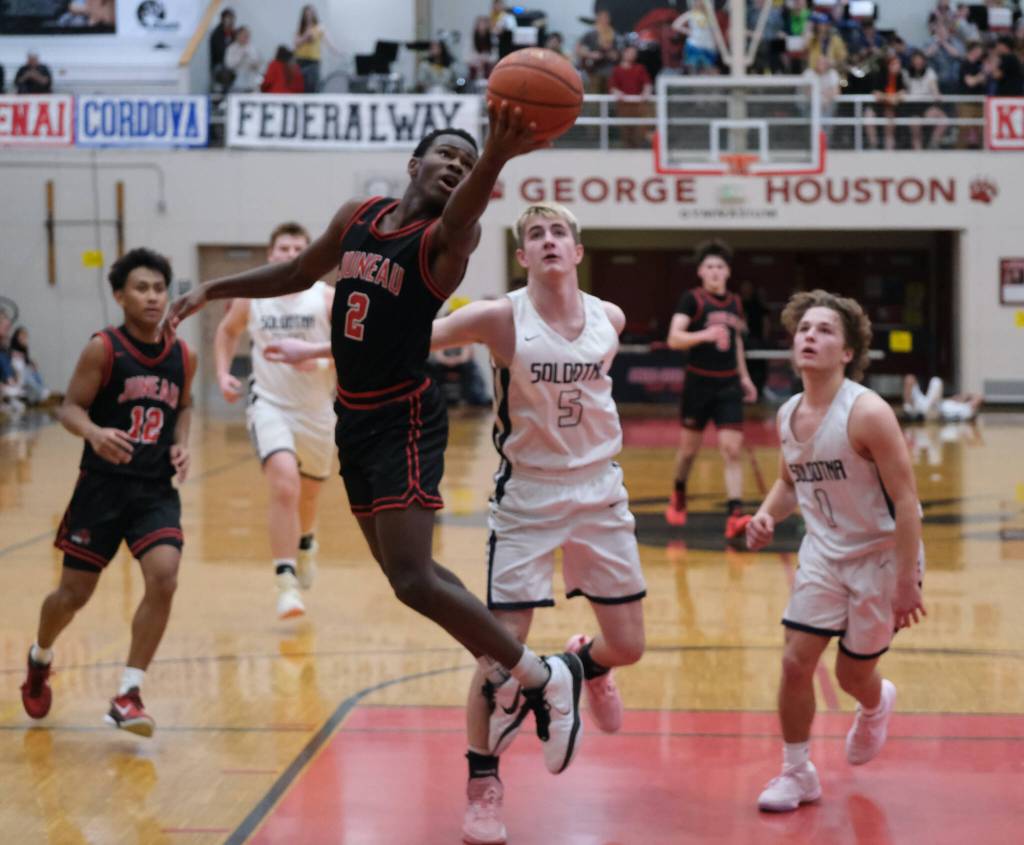 Juneau-Douglas High School: Yadaa.at Kalé senior Ahmir Parker (2) scores against Soldotna junior Bryan Berg (5) in the Crimson Bears 62-60 overtime loss to the Stars during Saturday action at the George Houston Capital City Classic in Juneau. (Klas Stolpe / Juneau Empire)