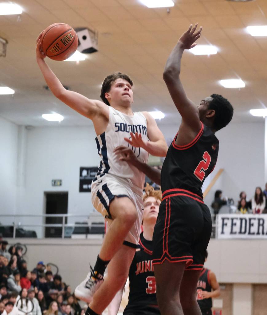 Soldotna senior Easton Hawkins (0) challenges Juneau-Douglas High School: Yadaa.at Kalé senior Ahmir Parker (2) in the Stars 62-60 overtime win over the Crimson Bears during Saturday action at the George Houston Capital City Classic in Juneau. (Klas Stolpe / Juneau Empire)