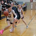 Juneau-Douglas High School: Yadaa.at Kalé senior Kerra Baxter dribbles over a screen by senior Mary Johnson and past Chugiak senior Emily Mullin (34) and freshman Kaitlyn Farr (3) during the Crimson Bears 51-38 win over the Mustangs in the girls championship game at the George Houston Capital City Classic on Sunday in Juneau. (Klas Stolpe / Juneau Empire)