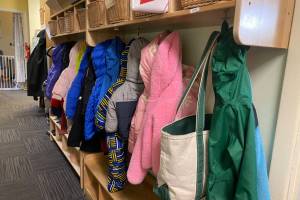 Childrens coats hang in a hallway at Hillcrest Childcare Center in Anchorage o n April 18. The second and final report of a child care task force holds recommendations for expanding subsidies that families receive, speeding the caregiver licensing and hiring process and other steps intended to address the states shortage of affordable child care. (Claire Stremple/Alaska Beacon)