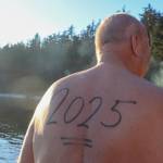 Jim Beckermann enters the water with 2025 on his back on New Years Day. (Jasz Garrett / Juneau Empire)