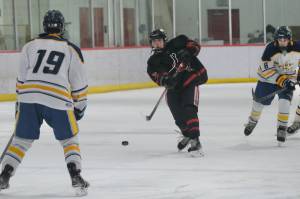 Juneau-Douglas High School: Yadaa.at Kalé junior Paxton Mertl (7) shoots against Bartletts Dylan Beals during the Crimson Bears 7-5 win over the Golden Bears Friday at the Treadwell Ice Arena. The teams play against Saturday at 3 p.m. (Klas Stolpe / Juneau Empire)