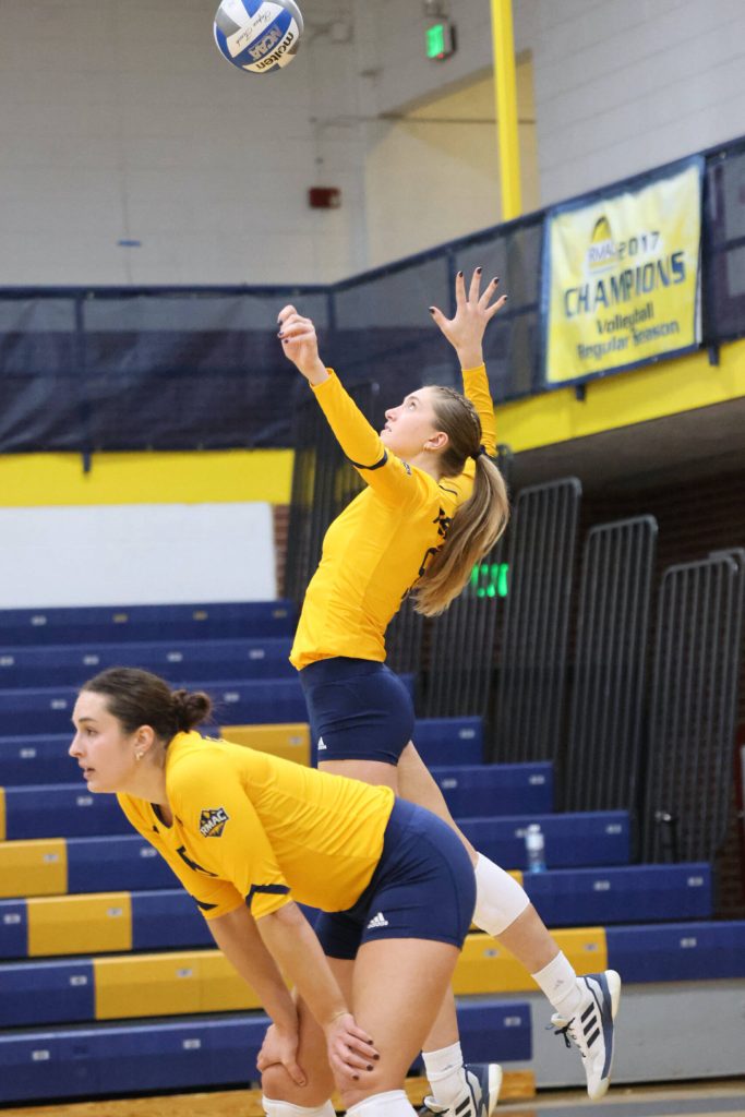 2022 Juneau-Douglas High School: Yadaa.at Kalé graduate Brooke Sanford (5) serves during a Regis University Rangers home volleyball match this season in Denver, Colorado. (Regis photo courtesy Makayla Salter)